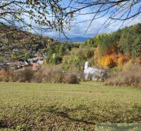 A church surrounded by autumn nature in Záhrady, Hlboké nad Váhom with a view of the mountains.