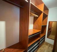 A wooden wardrobe with shelves and a mirror in a 3-room apartment.