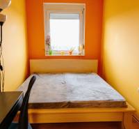 Bedroom with a bed, desk, and window in a 2-room apartment.