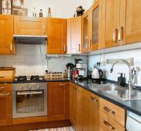 A kitchen with wooden cabinets and appliances in a 2-room apartment.