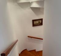 Spiral staircase with wood-patterned flooring in a family house.
