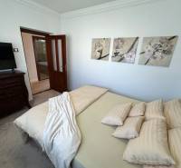 Bedroom of a family house with decorative paintings on the wall, upholstered furniture, and doors.