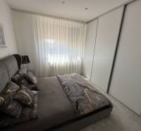 A bedroom in a family house with dark bedding and a large wardrobe.
