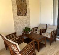 Seating on the terrace of a family house with wooden furniture and wall decoration.