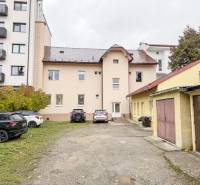 The building on Bratislavská Street in Žilina, surrounded by cars and garages, suitable for offices.