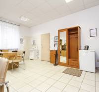 Office with furniture, a desk, chairs, and a sink.