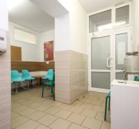 A waiting room in an office with turquoise chairs and a water dispenser.