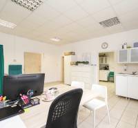 Office with furniture, computer, and kitchenette, with tiles on the floor.