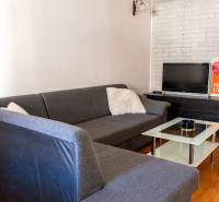 Living room in a 2-room apartment with a corner-arranged sofa and a television.