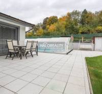 The terrace of a family house in Domaniža with garden furniture and a covered swimming pool.