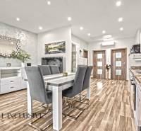 Dining area in a 3-room apartment with a wooden decor floor and a stylish mirror.