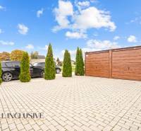 Parking lot by a 3-room apartment in Gabčíkovo, with cars and a wooden garage.