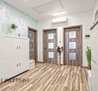 Interior of a 3-room apartment with a wood-patterned floor and white furniture.