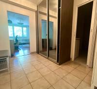 A hallway with a tiled floor and a built-in wardrobe in a 3-room apartment.