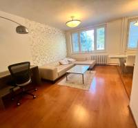 Living room in a 3-room apartment with a sofa, table, and desk.