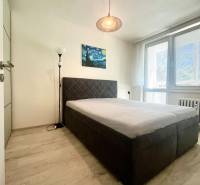 Bedroom with a double bed, a painting, and a floor lamp in a 3-room apartment.