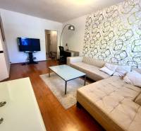 Living room with a beige sofa and a television in a three-room apartment.