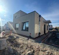 A family house under construction in Hubice with unlandscaped terrain. Clear sky and sunlight.