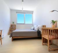 A bedroom in a villa with wooden elements and a floor with a wood decor.