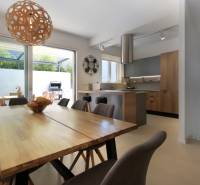 Interior of the villa with an open kitchen, dining table, and access to the terrace.