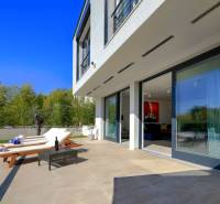 A villa in Bale with a terrace, loungers, a table, and a pool surrounded by greenery.