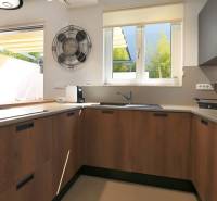 A kitchen in a villa with a large window, wooden cabinets, and a wooden decor floor.