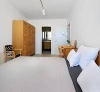 Bedroom in a villa with wooden furniture, a table, a chair, and a view into the bathroom.