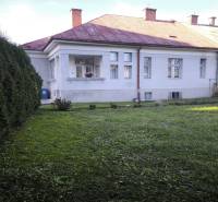 A family house in Uhlisko, Banská Bystrica, surrounded by landscaped greenery, with a veranda.