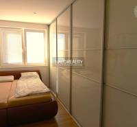 Bedroom in a 3-room apartment with a large wardrobe and a floor with a wooden decor.