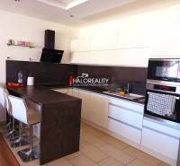 A kitchen with white cabinets and a bar counter in a 3-room apartment.
