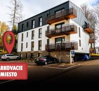 A modern apartment building on Lúčná Street in Štrba with parking space in front of the building.