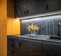 A kitchen unit in a 2-room apartment with a marble effect and a wooden cabinet.