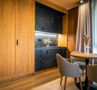 A kitchen corner with black marble decor and a floor with wooden decor in a 2-room apartment.