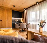 Interior of a 2-room apartment with a wooden decor floor, stylish furniture, and curtains.