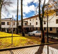 The hotel building in Štrba on Lúčná surrounded by trees, with a parked car.