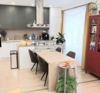 Interior of a kitchen in a 3-room apartment with a dining table and a wooden decor floor.