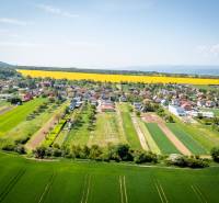 Aerial view of Vyšná Šebastová street with vast fields and family houses in the countryside.
