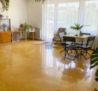 Spacious bright living room, wooden decor flooring, furniture and plants in a family house.