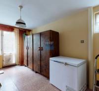 Interior of a family house with a freezer, cabinets, and a large window.