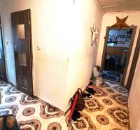 A hallway in a 2-room apartment with decorative tiles and furniture.