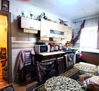 A kitchen in a 2-room apartment with a light wooden decor floor and rich furnishings.