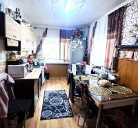 A kitchen in a 2-room apartment with a wooden decor floor and a dining table.