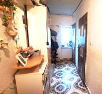 A hallway with lockers and decorations in a 2-room apartment. On the left, there are hangers, on the right, doors.