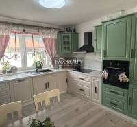 A kitchen in a family house with wooden furniture and curtains.
