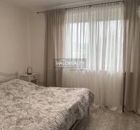 Bedroom with a bed and curtains in a family house, bright atmosphere.