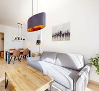 Living room in a 2-room apartment with a sofa and a dining table, floor with wood decor.
