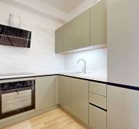 A kitchen in a 2-room apartment with a wood-patterned floor and modern appliances.