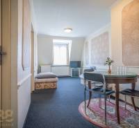 A room in hotels and guesthouses with a round table and a TV on a stand.