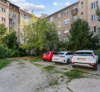 Parking lot with trees in front of a residential building on Vajnorská in Bratislava - Nové Mesto.