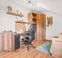 Office in a family house with wooden decor, trophies, and a desk.